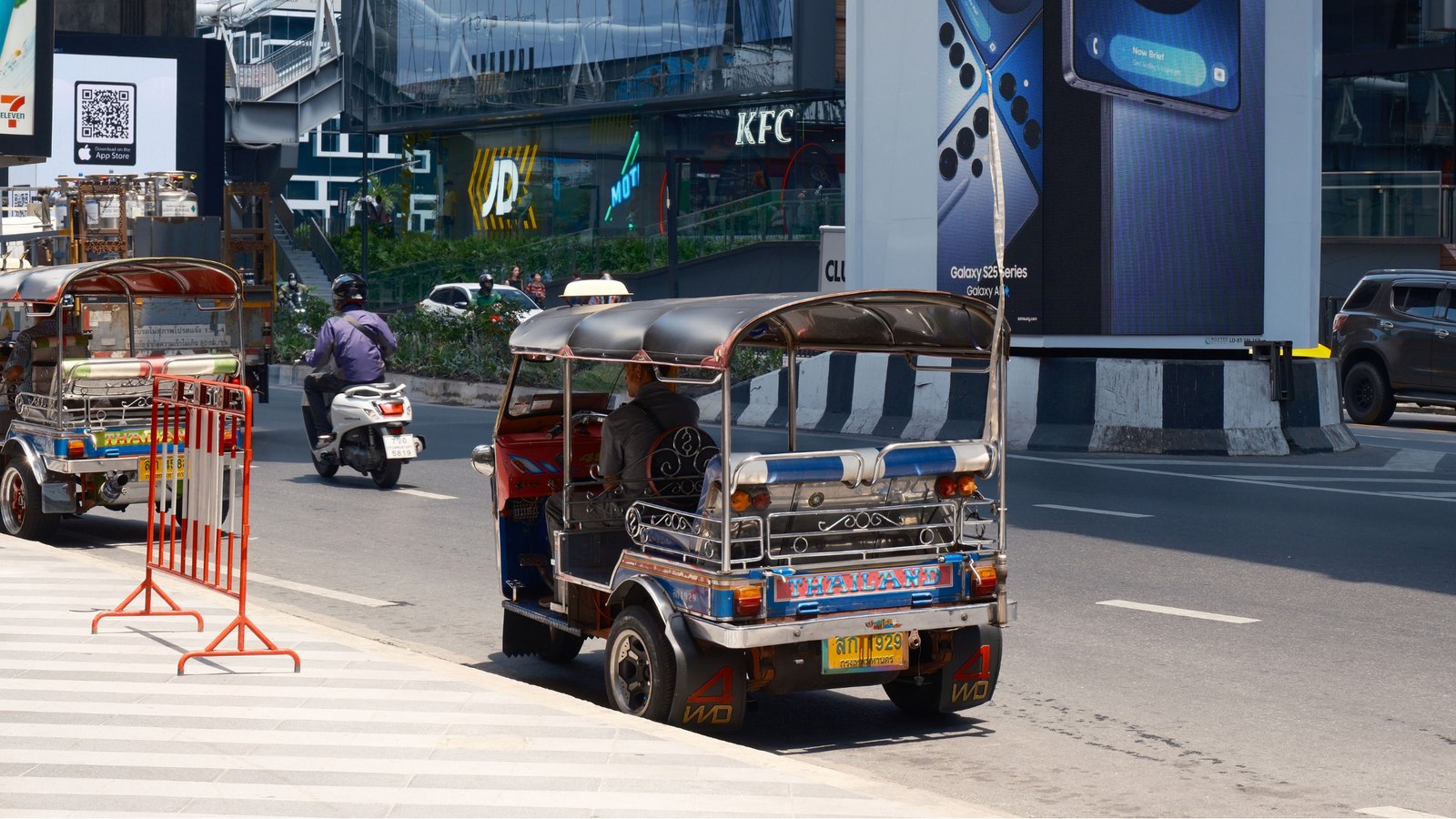 A Bangkok street scene with a digital billboard, illustrating the city's fast-moving tech adoption