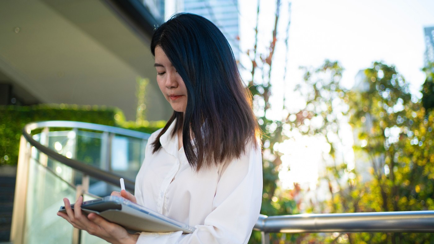 A professional reviewing workforce plans on a tablet outdoors